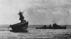 Guarded by a destroyer, the Yorktown lists dangerously to port.