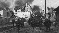German troops advance into a Polish town behind the cover of an armoured car, September 1939.